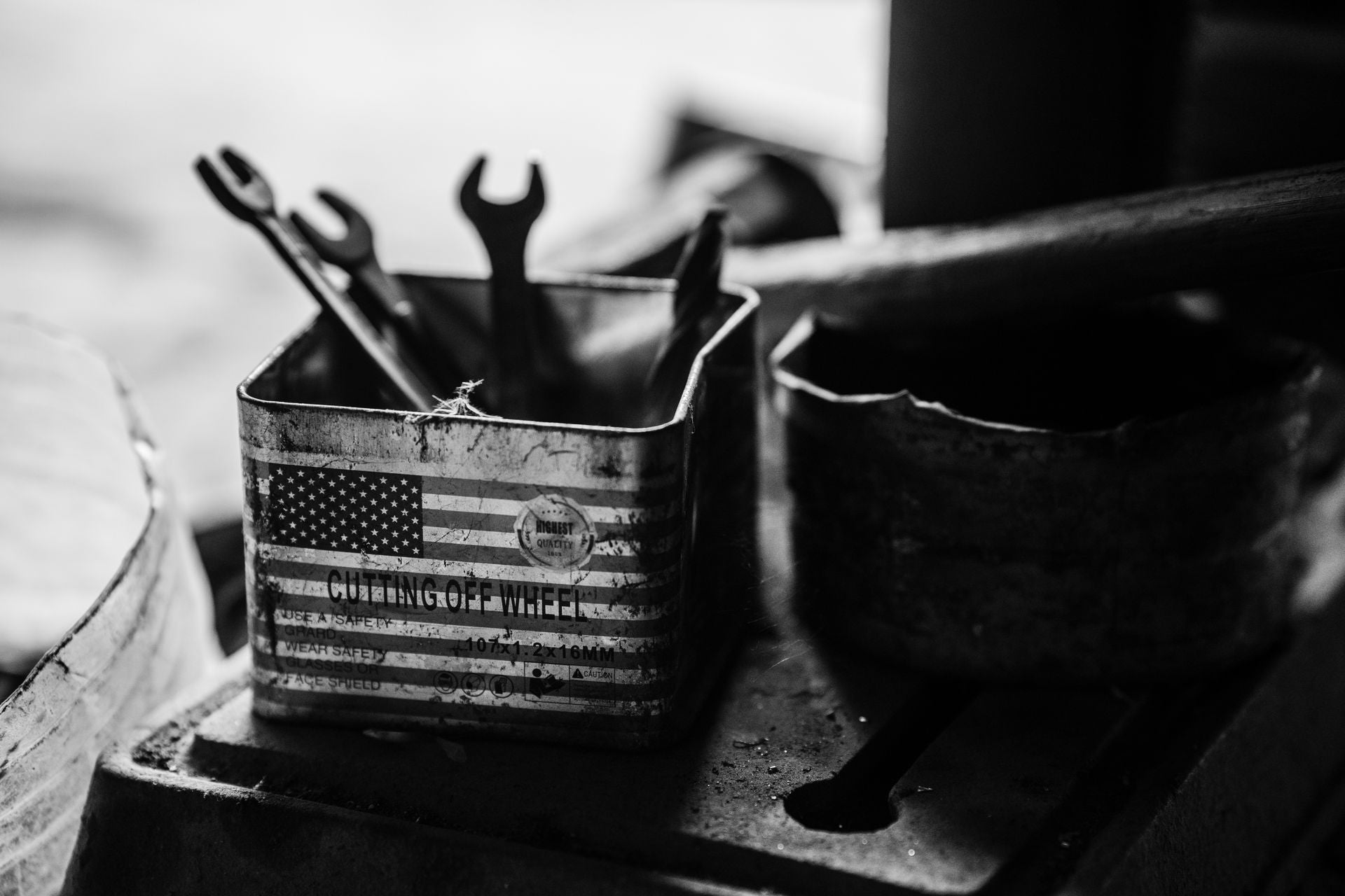 Vintage wrenches in a weathered American flag tin